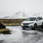 Coche en carretera al atardecer — road trip barato